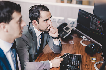 Image showing Stock brokers looking at computer screens, trading online.