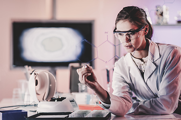 Image showing Portrait of a confident female researcher in life science laboratory writing structural chemical formula on a glass board.