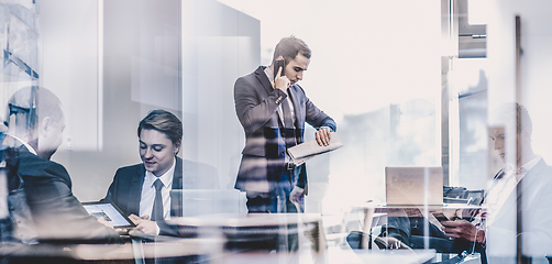 Image showing Businessman talking on a mobile phone on corporate office.