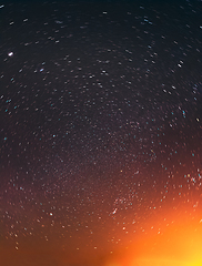 Image showing Night Sky Glowing Stars Background Backdrop In Rotation. Colorful Sky Gradient. Sunset Sunrise Light And Colourful Night Starry Sky In Yellow Orange Black Colors. Copy Space