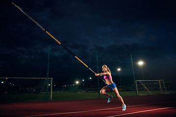 Image showing Female pole vaulter training at the stadium in the evening