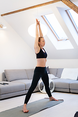 Image showing Beautiful blonde woman doing home workout indoors. Woman practice yoga at home. Fit girl using workout tutorials for healthy active lifestyle. Woman using quarantine for home workouts.