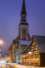 Image showing Parnu, Estonia. Night View Of Kuninga Street With Old Houses, Restaurants, Cafe, Hotels And Shops In Evening Night Illuminations. View Of Lutheran Church Of St. Elizabeth On Background