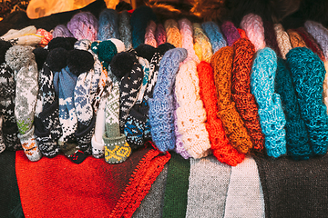 Image showing Traditional Christmas Winter Market Trading Houses With Warm Clothes, Wear And Hats. Colorful Knitted Traditional European Warm Clothes - Mittens and Scarfs. Xmas Souvenir From Europe.