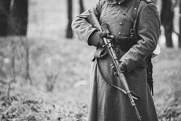 Image showing Close up of German military ammunition of a German soldier at World War II. Warm autumn clothes, soldier\'s overcoat, gloves, rifle. Black And White Photo. WWII Copy Space