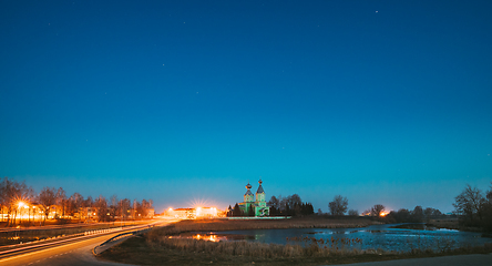 Image showing Old Russian Wooden Orthodox Church Of The Holy Trinity Under Night Starry Sky In Village Krupets, Dobrush District, Gomel Region, Belarus. Historical Heritage. Panorama, Panoramic View