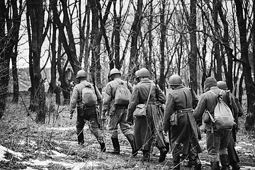 Image showing Group Of Re-enactors Dressed As Soviet Russian Red Army Infantry Soldiers Of World War II Marching Along Forest Road At Autumn Season. Black And White. Group Of Re-enactors Dressed As Soviet Russian 