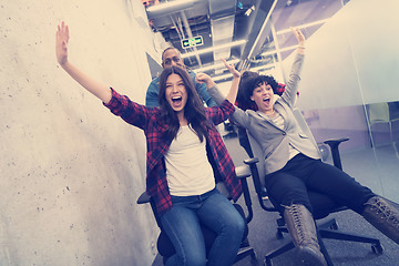 Image showing multiethnics business team racing on office chairs