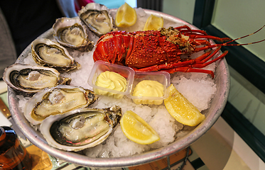 Image showing Large dish of fresh seafood, oysters with lobster with lemon and