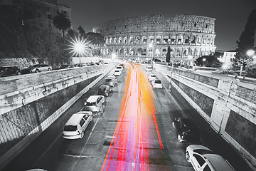 Image showing Rome, Italy. Colosseum, Flavian Amphitheatre In Night Time. Night Traffic Light Trails Near Famous World Landmark. All colors except red, pink and yellow are reduced. black and white. Rome, Italy. Co