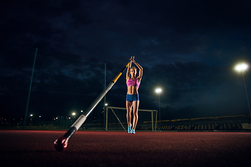 Image showing Female pole vaulter training at the stadium in the evening