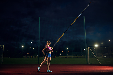 Image showing Female pole vaulter training at the stadium in the evening