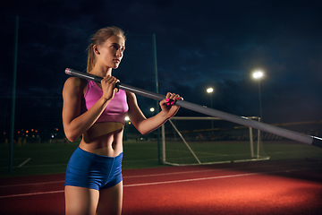 Image showing Female pole vaulter training at the stadium in the evening