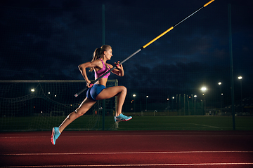 Image showing Female pole vaulter training at the stadium in the evening