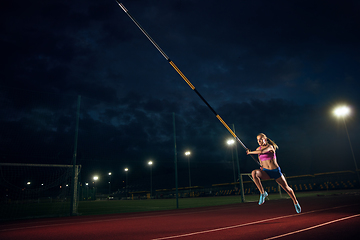 Image showing Female pole vaulter training at the stadium in the evening