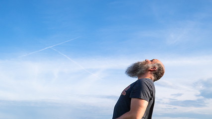 Image showing man looking up to the blue sky