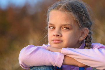 Image showing Portrait of a thoughtful beautiful ten-year-old girl at sunset