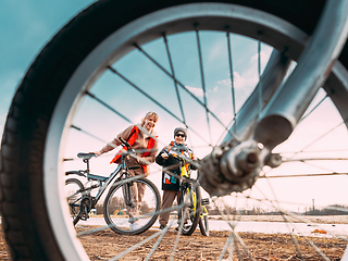 Image showing Caucasian Happy Mother And Son Riding Together And Posing For Photo. View From Bicycle Wheel, Family Riding Bicycles. Mothers Day, Mother Day, Mothersday Holiday. Healthy Lifestyle On Spring Nature