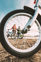 Image showing Caucasian Happy Mother And Son Riding Together And Posing For Photo. View From Bicycle Wheel, Family Riding Bicycles. Mothers Day, Mother Day, Mothersday Holiday. Healthy Lifestyle On Spring Nature