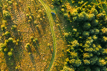 Image showing Aerial View Of Car Near Country Road Thgrough Forest And Green Meadow Landscape In Sunny Summer Morning. Top View Of Beautiful European Nature From High Attitude