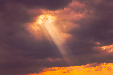 Image showing Sunshine In Sunrise Bright Dramatic Sky. Sun Ray Through Dark Rainy Clouds. Scenic Colorful Sky At Dawn. Sunset Sky Natural Abstract Background