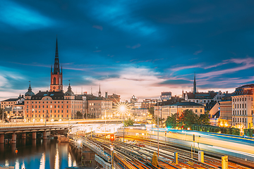 Image showing Stockholm, Sweden. Scenic View Of Stockholm Skyline At Summer Sunset. Riddarholm Church And Subway Railway With Train In Blurred Motion