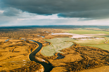 Image showing Aerial View Of Dry Grass And Partly Frozen River Landscape In Late Autumn Day. High Attitude View. Marsh Bog. Drone View. Bird\'s Eye View