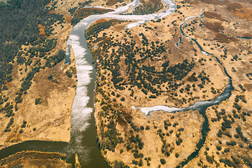 Image showing Aerial View Curved River In Early Spring Landscape. River bends Curves and dry grass landscape. Top View Of Beautiful European Nature From High Attitude. Drone View. Bird\'s Eye View