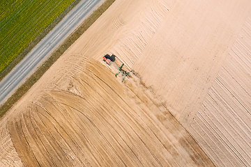 Image showing Aerial View. Tractor Plowing Field. Beginning Of Agricultural Spring Season. Cultivator Pulled By A Tractor In Countryside Rural Field Landscape. Dust Rises From Under Plows