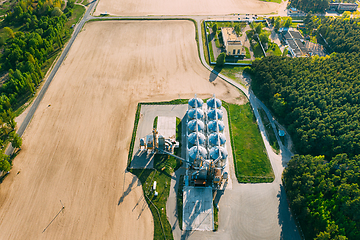 Image showing Aerial View Modern Granary, Grain-drying Complex, Commercial Grain Or Seed Silos In Sunny Spring Rural Landscape. Corn Dryer Silos, Inland Grain Terminal, Grain Elevators Standing In A Field