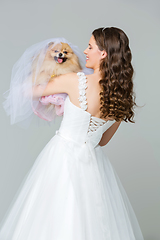 Image showing beautiful bride girl with spitz bride on gray background