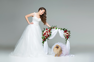 Image showing bride girl with dog bride under flower arch