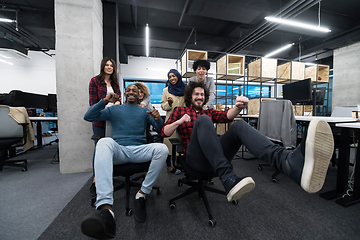 Image showing multiethnics business team racing on office chairs