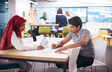 Image showing black muslim business woman having a meeting with her indian mal