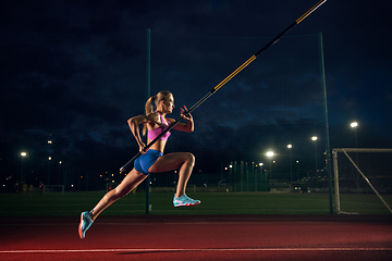 Image showing Female pole vaulter training at the stadium in the evening