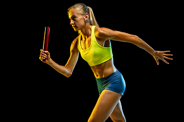 Image showing Professional female relay racer training on black studio background in neon light