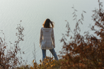 Image showing Slender girl standing on the seashore, rear view