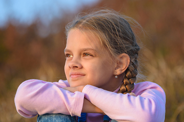 Image showing Portrait of a beautiful ten-year-old girl looking at the sunset, close-up