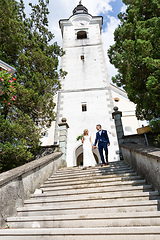Image showing The Kiss. Bride and groom kisses tenderly on a staircase in front of a small local church.