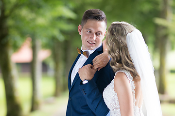 Image showing Bride and groom hugging tenderly posing during photo shooting in park.