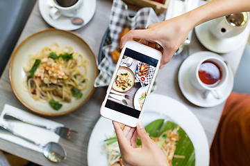 Image showing Top view of woman taking photo on dishes