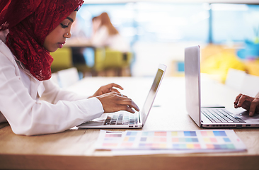 Image showing black muslim business woman ,working on laptop computer