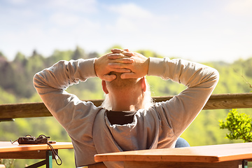 Image showing An old man relaxes in the sun