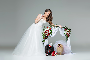 Image showing bride girl with dog wedding couple under flower arch
