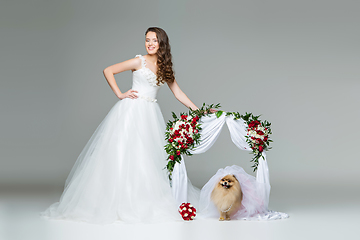 Image showing bride girl with dog bride under flower arch