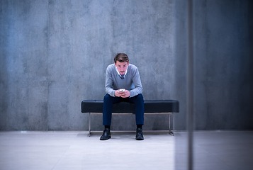 Image showing businessman using smart phone while sitting on the bench