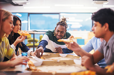 Image showing multiethnic business team eating pizza