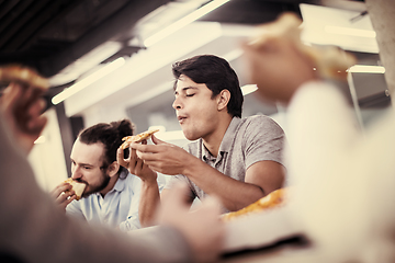 Image showing multiethnic business team eating pizza