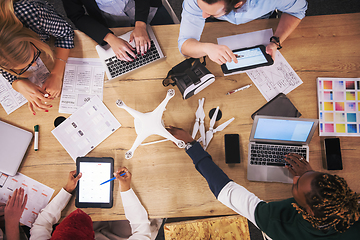 Image showing top view of multiethnic business team learning about drone techn