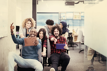 Image showing multiethnics business team racing on office chairs